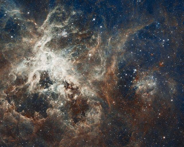 Schulklasse während Klassenfahrt zu Besuch im Planetarium Köln. Auf dem Bild sehen wir einen leuchtenden Sternenkomplex, den Tarantelnebel, auch 30 Doradus genannt. Dieser kolossale Haufen Sternenstaub ist ein in der Großen Magellanschen Wolke im Sternbild Schwertfisch gelegener, sehr hellen Emissionsnebels. Er ist ein bekanntes Sternentstehungsgebiet.